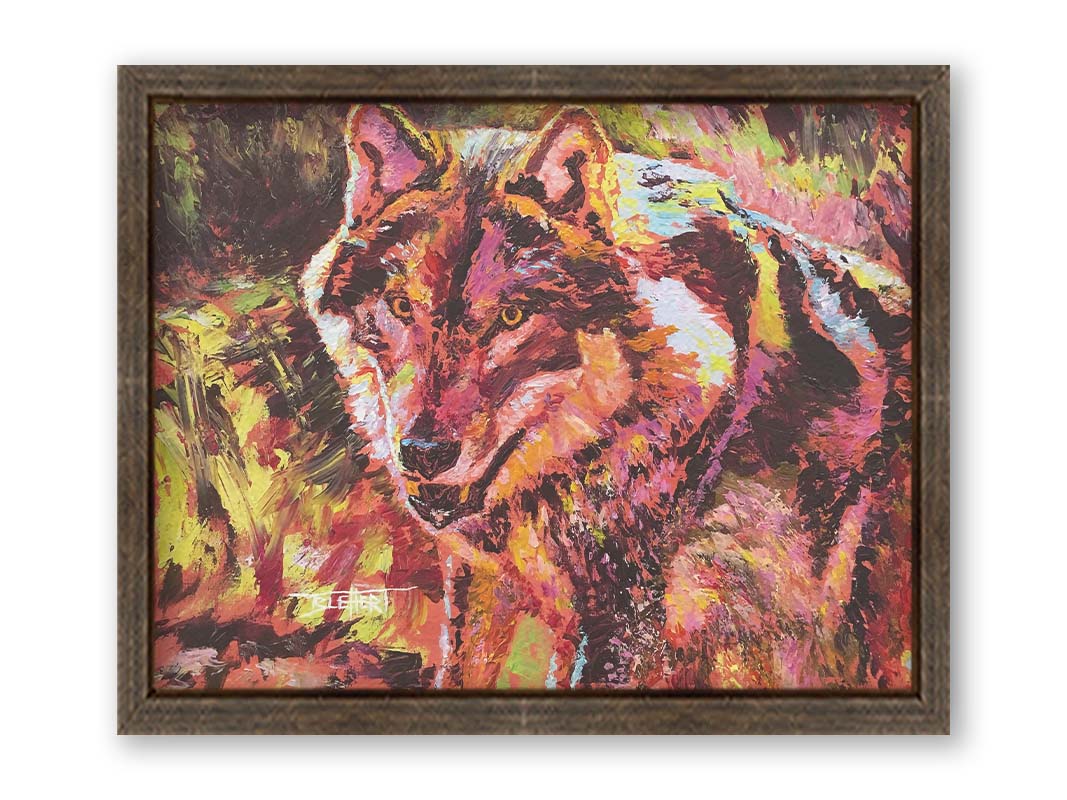 A painting of a wolf rendered in reds and yellows. Printed on canvas and framed.