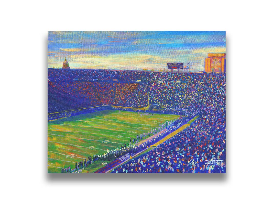 A painting of the Notre Dame Stadium in Notre Dame, Indiana. The stands are full as the crowd excitedly watches the football game. Printed on canvas.