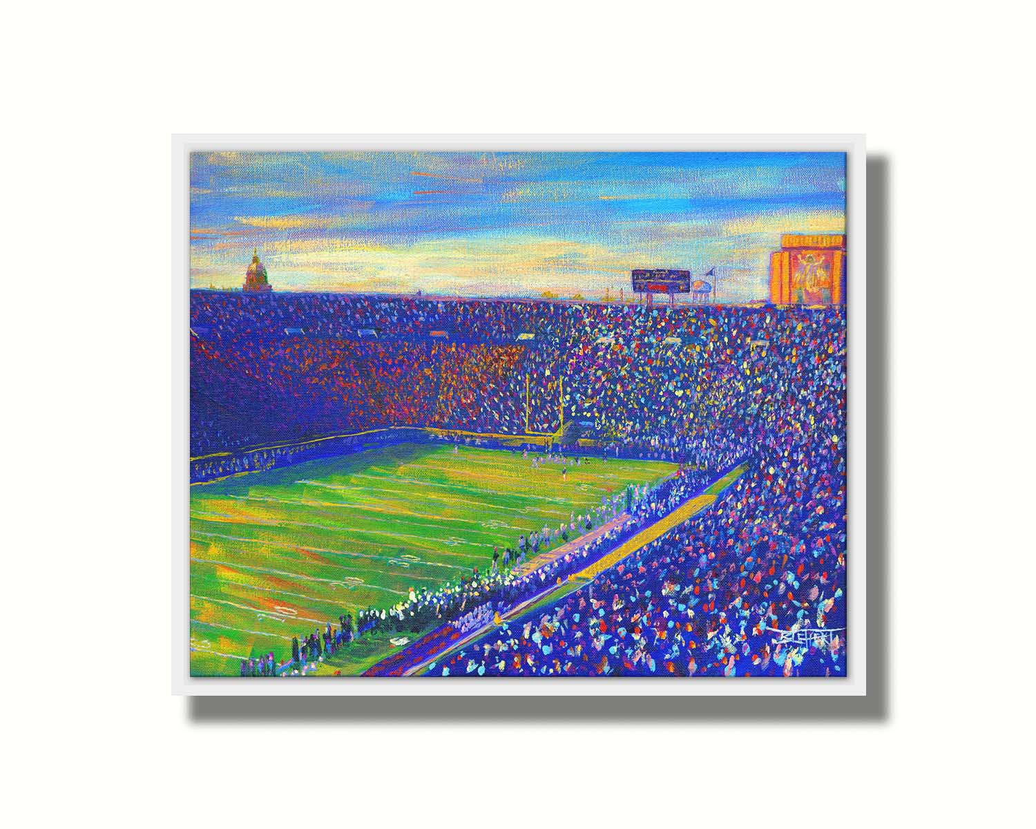 A painting of the Notre Dame Stadium in Notre Dame, Indiana. The stands are full as the crowd excitedly watches the football game. Printed on canvas in a float frame.