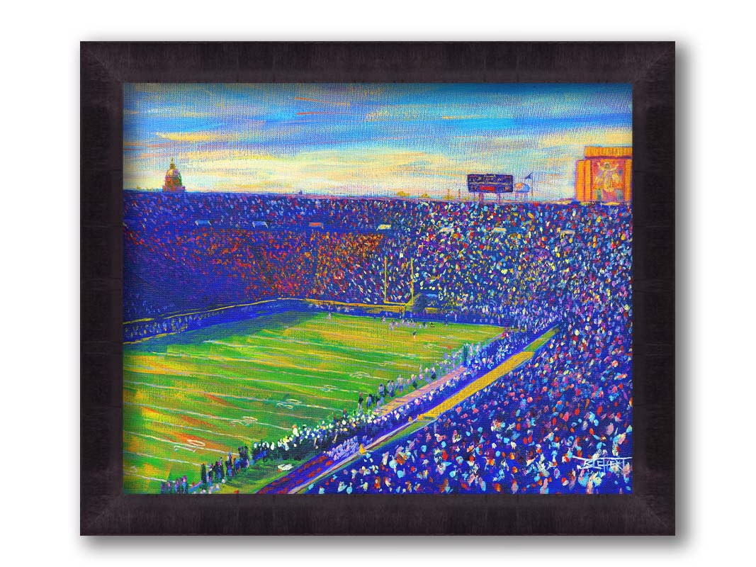 A painting of the Notre Dame Stadium in Notre Dame, Indiana. The stands are full as the crowd excitedly watches the football game. Printed on canvas and framed.