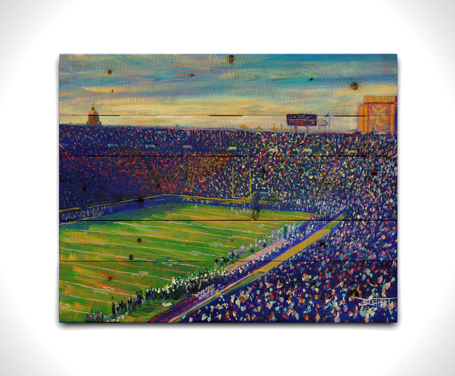 A painting of the Notre Dame Stadium in Notre Dame, Indiana. The stands are full as the crowd excitedly watches the football game. Printed on a wood pallet.