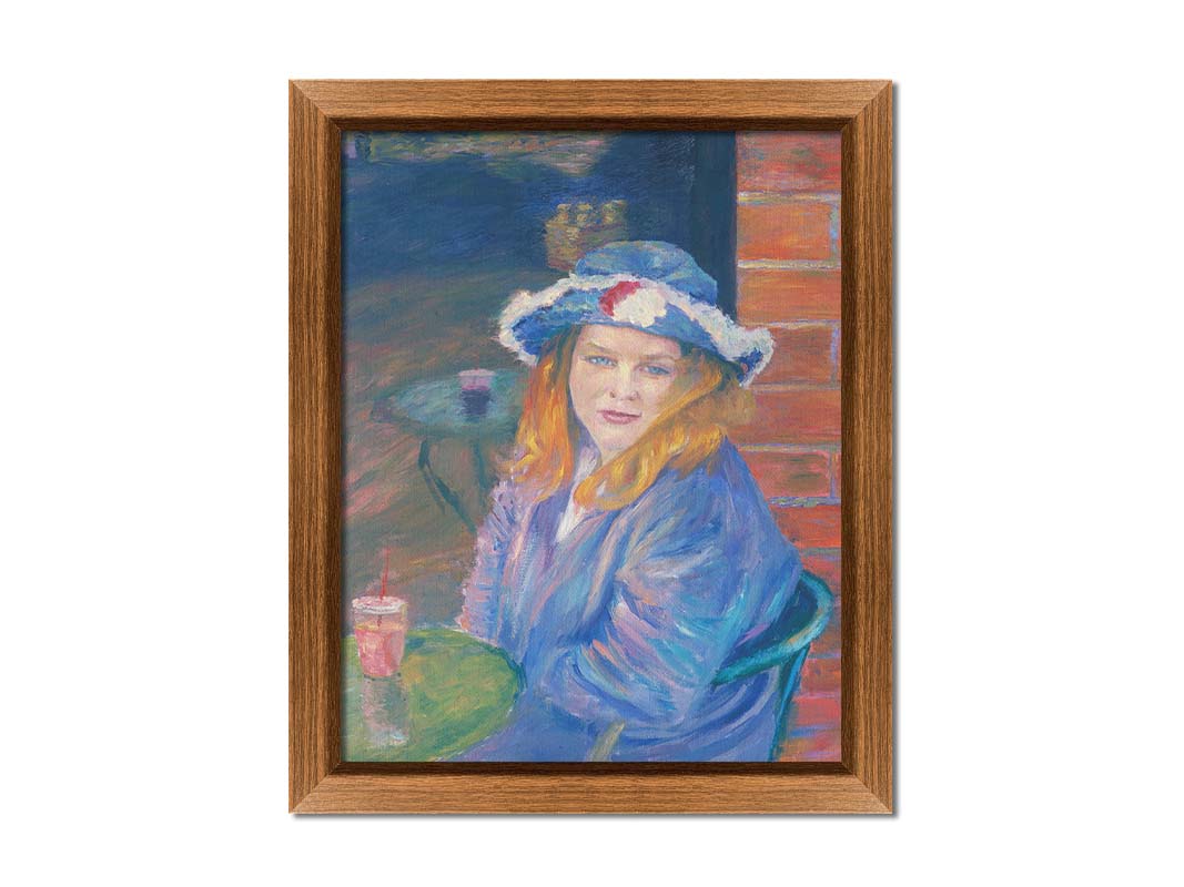 A portrait of a person in a blue outfit, sitting at a table outside a brick building with a drink. Printed on canvas and framed.