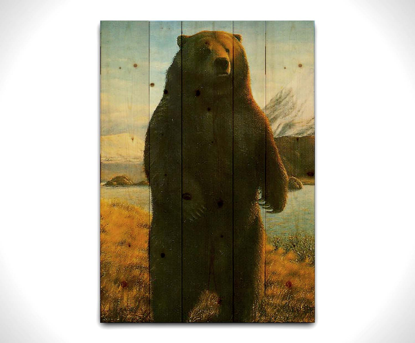 A portrait painting of a brown bear standing on its back legs in a yellow field, next to a lake and mountain range. Printed on a wood pallet.