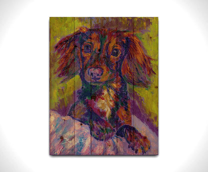 A painting of a dachshund, or wiener dog, lying on a cushion or blanket. It is perking up playfully, and it is painted using a purple, green, and brown palette. Printed on a wood pallet.