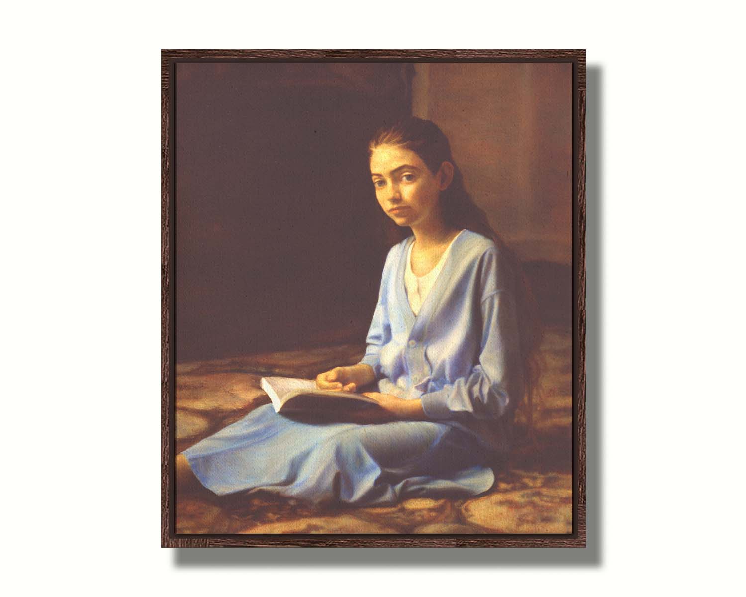 A portrait painting of a young girl dressed in blue and sitting on the floor, reading a book. It is painted in a softly lit, realistic, classical style reminiscent of the Renaissance. Printed on canvas in a float frame.