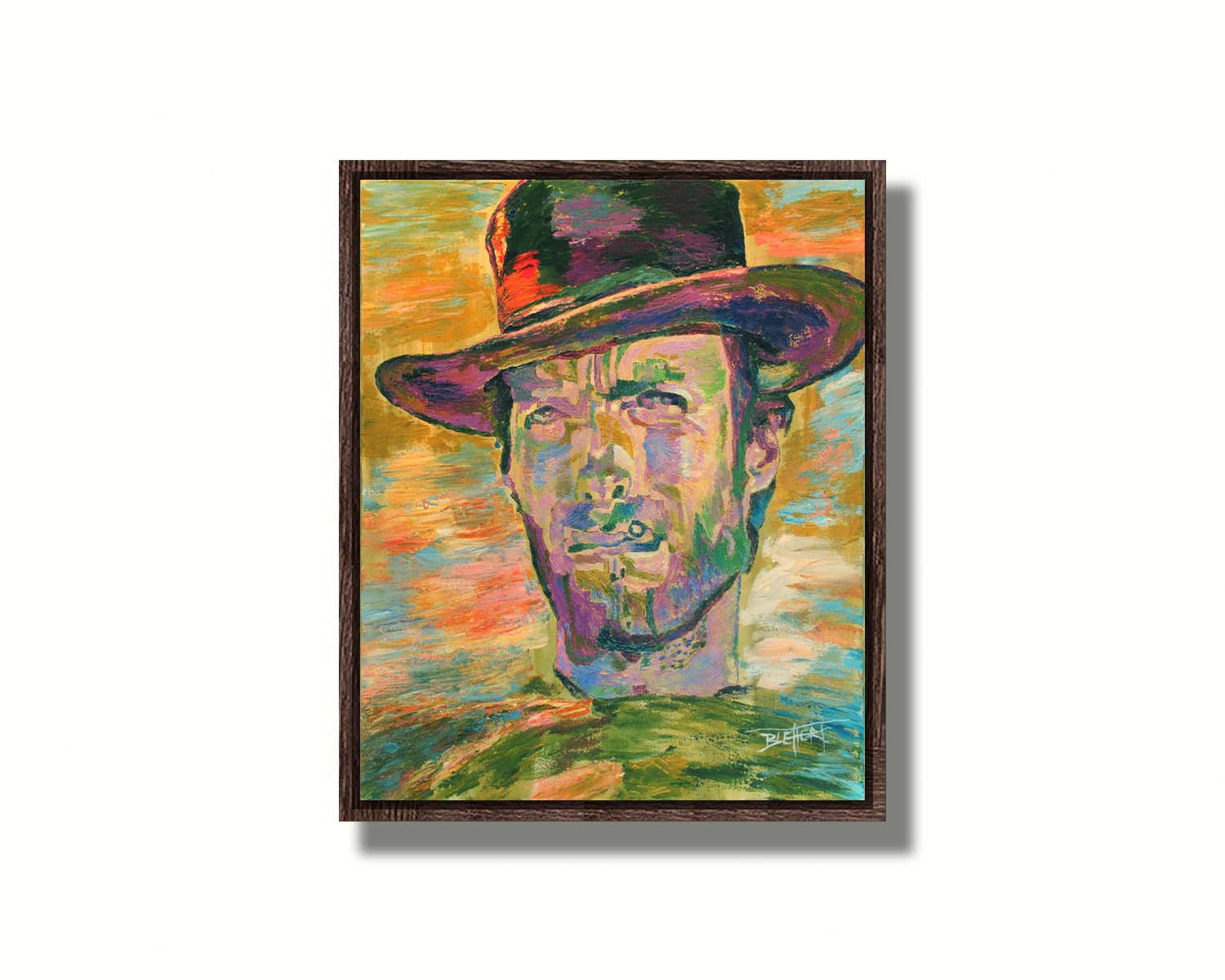 A portrait painting in yellows and greens of actor Clint Eastwood dressed for his classic western roles. Printed on canvas in a float frame.