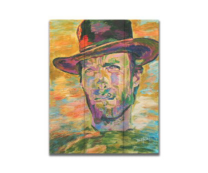 A portrait painting in yellows and greens of actor Clint Eastwood dressed for his classic western roles. Printed on a box board.