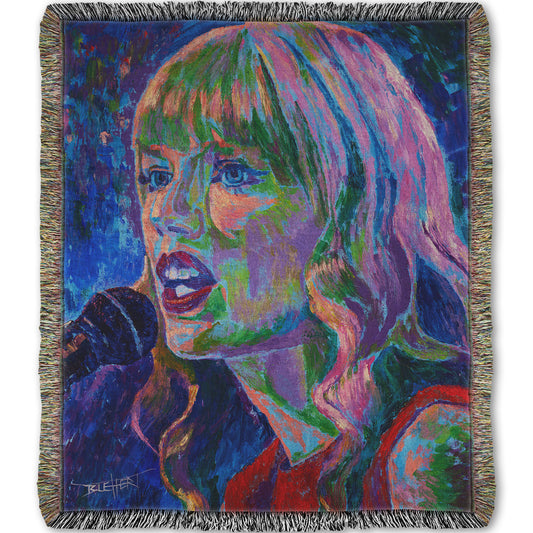 Woven throw blanket with a colorful portrait of Taylor Swift singing into a microphone.