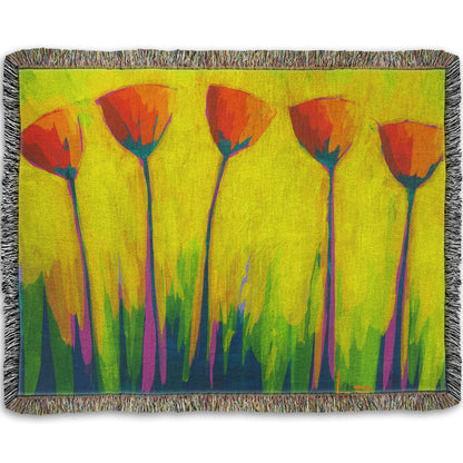 A woven throw blanket designed with a painting of five simplified red flowers against a striking yellow and green background.