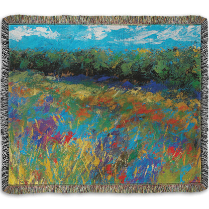 A woven throw blanket designed with an expressive painting of a field of flowers, created in bold strokes of color.