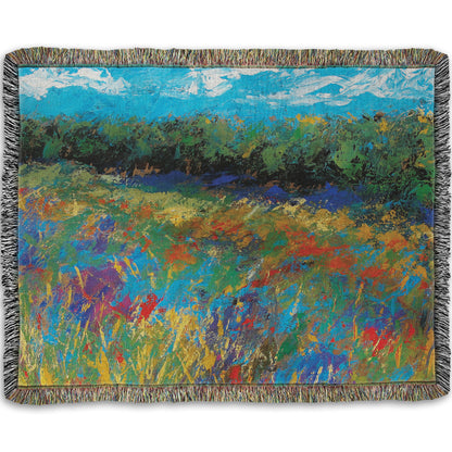 A woven throw blanket designed with an expressive painting of a field of flowers, created in bold strokes of color.