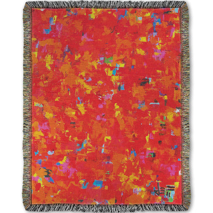 Woven blanket designed with a painting of an abstract organic pattern of red, orange, and yellow accented by blue, pink, green, black, and white.