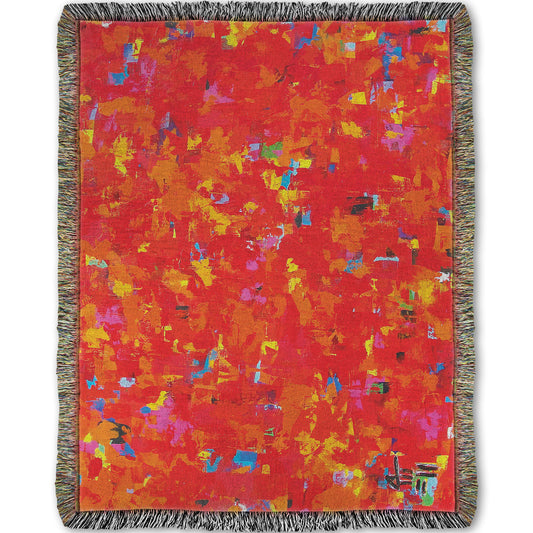Woven blanket designed with a painting of an abstract organic pattern of red, orange, and yellow accented by blue, pink, green, black, and white.