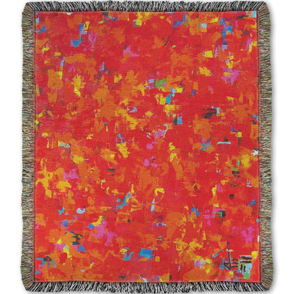 Woven blanket designed with a painting of an abstract organic pattern of red, orange, and yellow accented by blue, pink, green, black, and white.