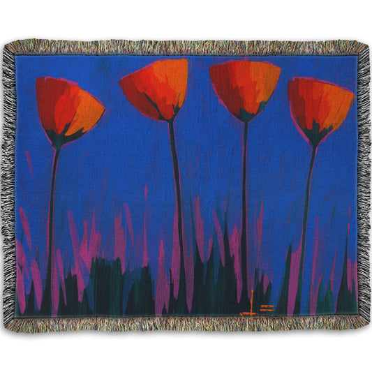 A woven throw blanket designed with a painting of four simplified red flowers against a dark blue and purple background.