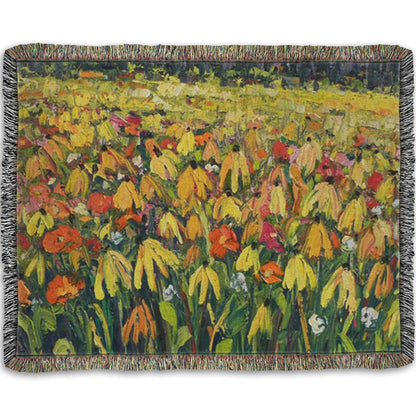 A woven throw blanket designed with a painting of a field of yellow coneflowers, accented by other orange, pink, red, and white wildflowers.