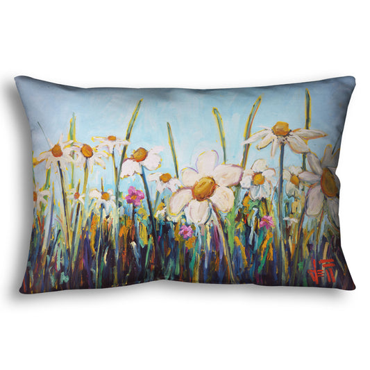 A throw pillow designed with a painting of a wildflower field from a low angle, full of white daisies accented by small pink flowers.