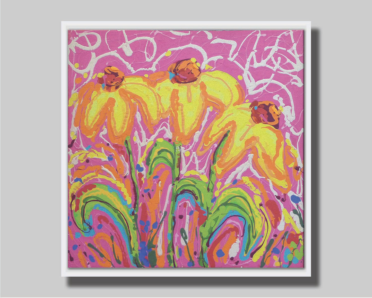 A painting of three yellow wildflowers on a pink background, accented by orange, blue, green, and white. It was created by dripping paint onto the substrate. Printed on canvas in a float frame.