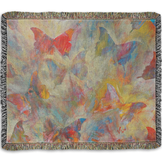 A woven throw blanket designed with an abstracted painting of a pattern of butterflies, created in an array of colors with textured brushstrokes.