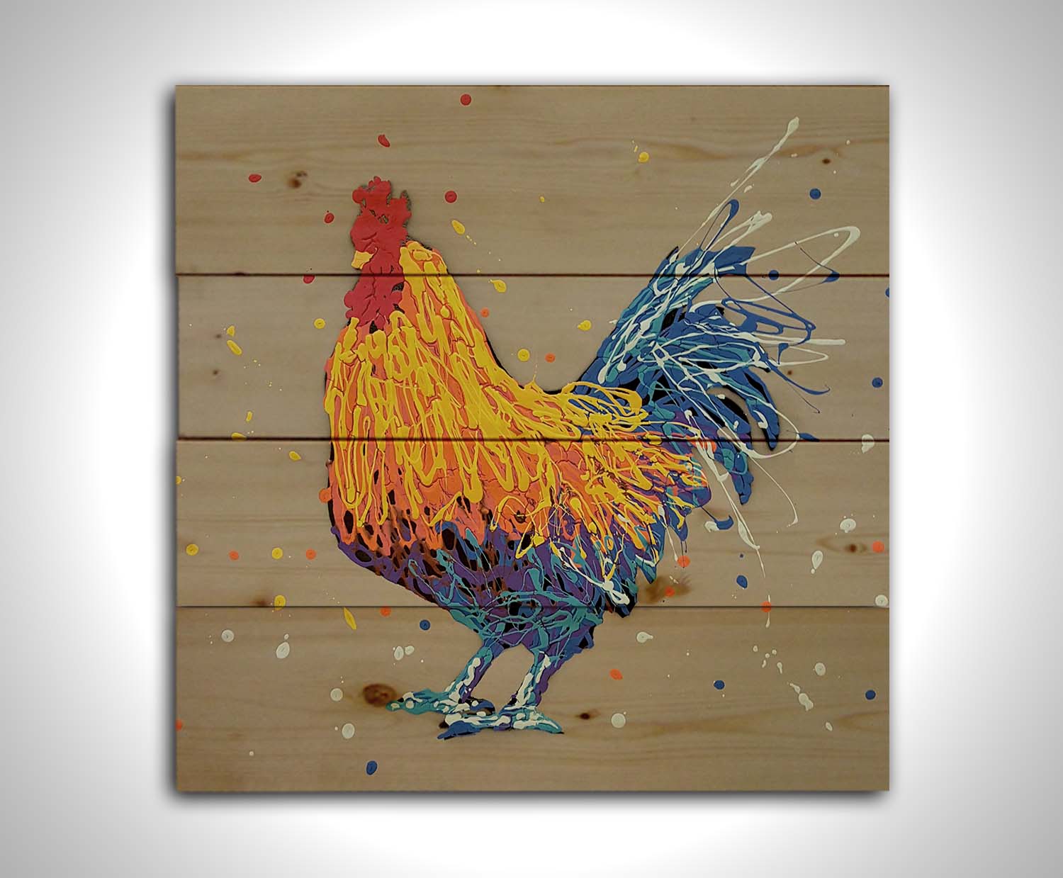 A drip painting portrait of a rooster in red, orange, yellow, blue, and purple against a gray background. Printed on a wood pallet.