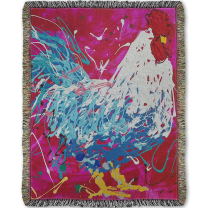 A woven throw blanket designed with a drip painting of a white and blue rooster on a red and pink background, accented by white, yellow, green, and brown.