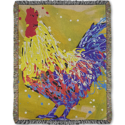 A woven throw blanket designed with a drip painting of a yellow and blue rooster, accented by red and white, against a yellow-green background.