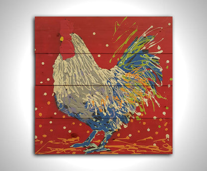 A drip painting of a white, gray, and blue rooster on a red background, accented by yellow and green. Printed on a wood pallet.