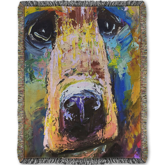 A woven throw blanket designed with a painting of a bear's face closeup, accented with blue and yellow.