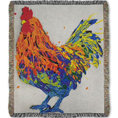 A woven blanket designed with a drip painting of a multicolored rooster on a white background.