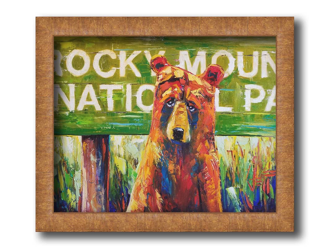 A painting of a bear standing in front of a "Rocky Mountain National Park" sign. Printed on canvas and framed.