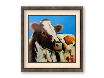 A painting of a cow basking in the sun against a bright blue background. Printed on paper, matted, and framed.