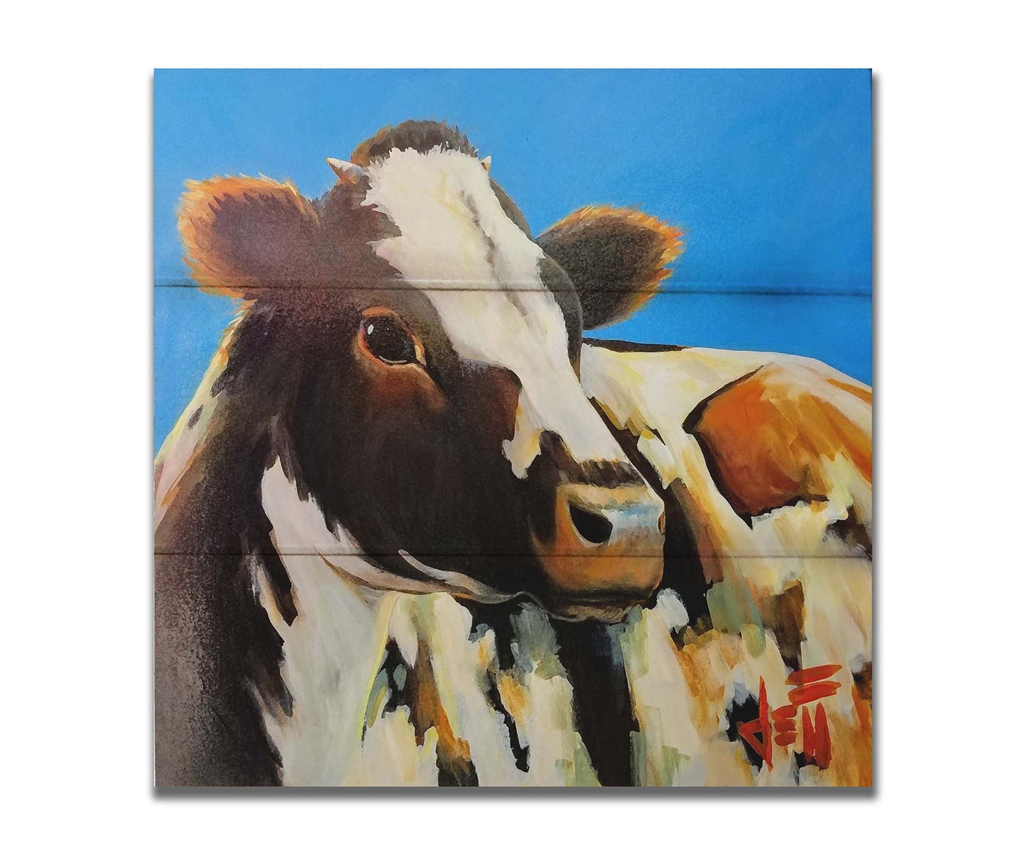 A painting of a cow basking in the sun against a bright blue background. Printed on a box board.