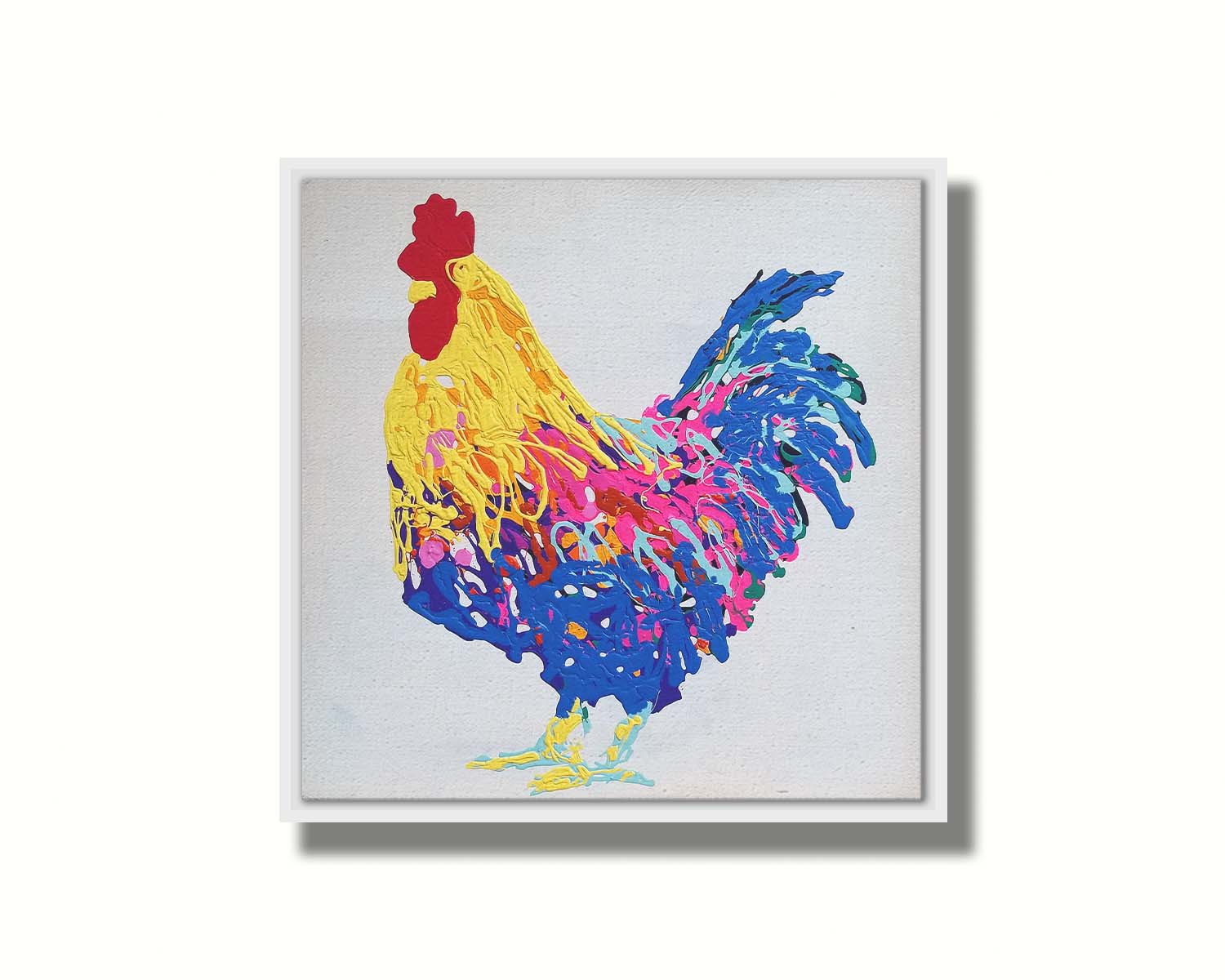 A drip painting of a yellow, blue, and pink rooster on a white background. Printed on canvas in a float frame.