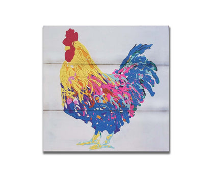 A drip painting of a yellow, blue, and pink rooster on a white background. Printed on a box board.