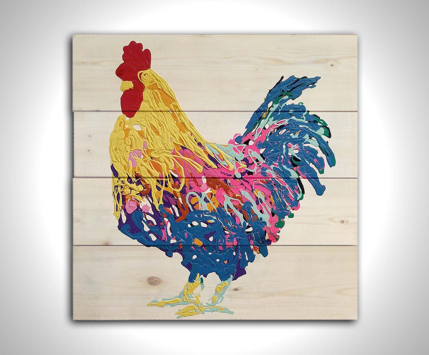 A drip painting of a yellow, blue, and pink rooster on a white background. Printed on a wood pallet.