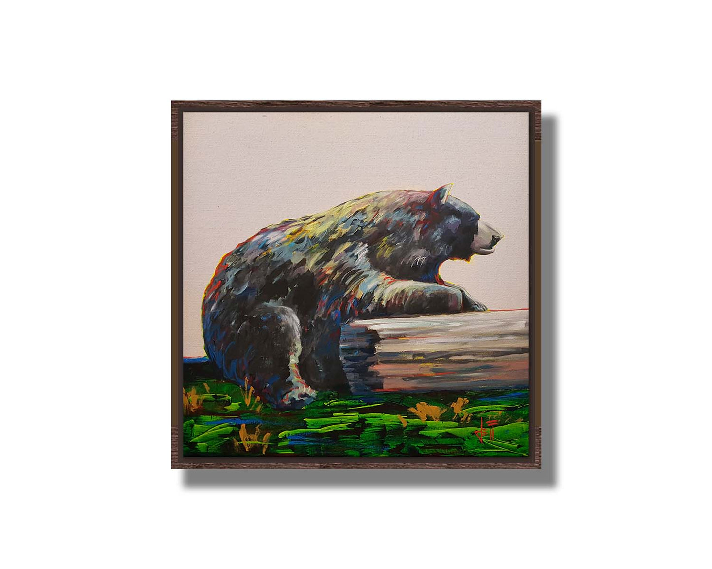 A painting of a bear accented with red, yellow, and blue sitting against a log on bright green grass with a pale pink background. Printed on canvas in a float frame.