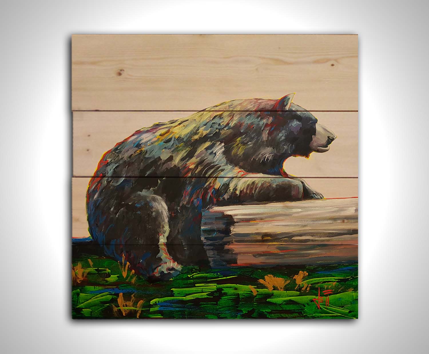 A painting of a bear accented with red, yellow, and blue sitting against a log on bright green grass with a pale pink background. Printed on a wood pallet.