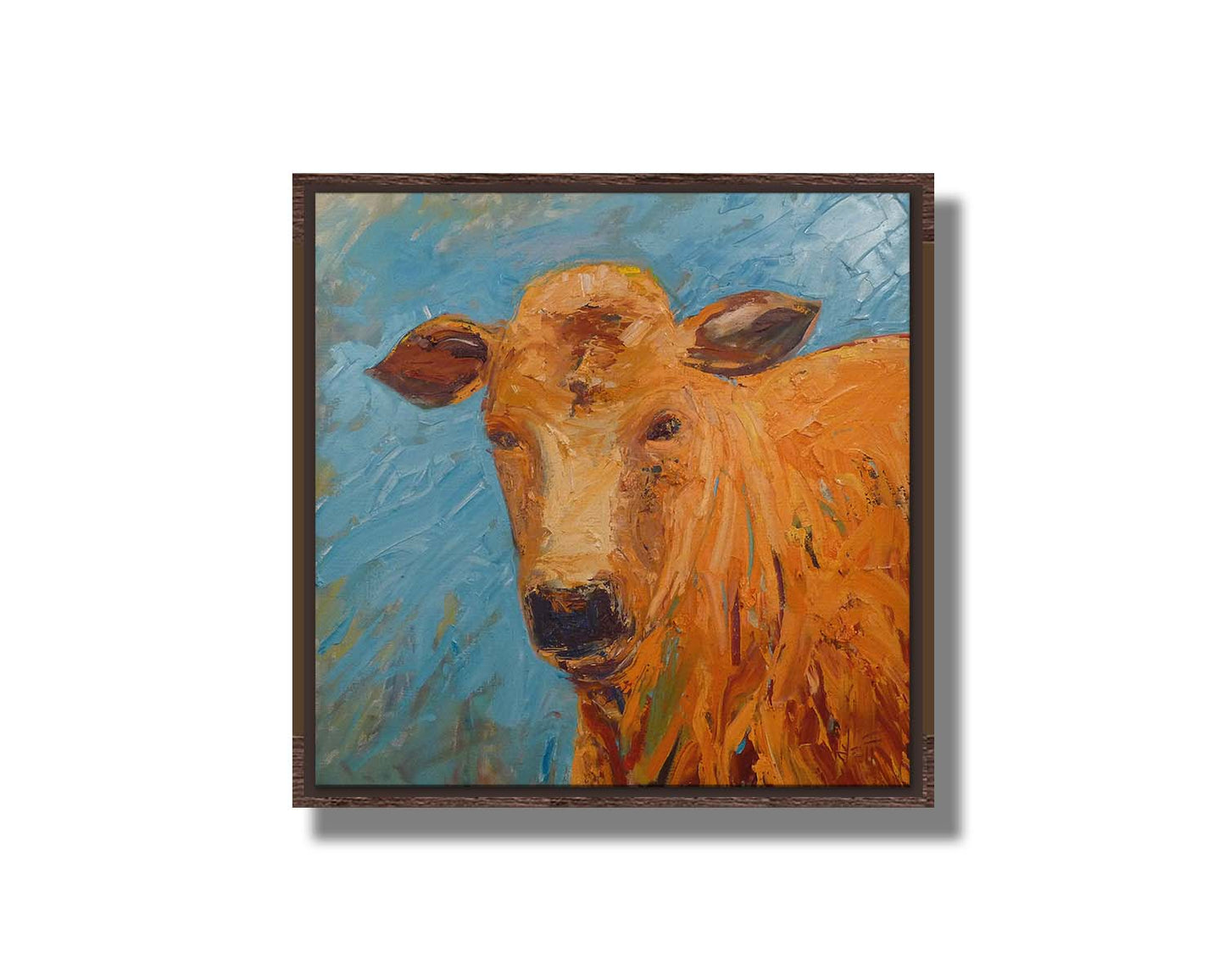 An expressive painting of an orange-brown cow's face against a blue background. Printed on canvas in a float frame.