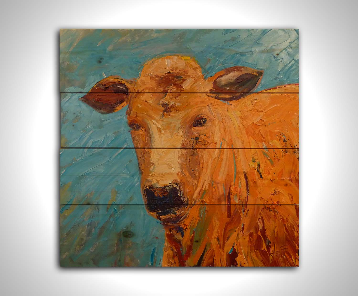 An expressive painting of an orange-brown cow's face against a blue background. Printed on a wood pallet.