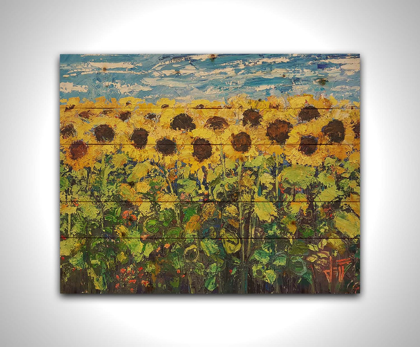 An expressive painting of a yellow field of sunflowers against a bright blue sky. It is highly textured with visible brushstrokes and thick paint. Printed on a wood pallet.