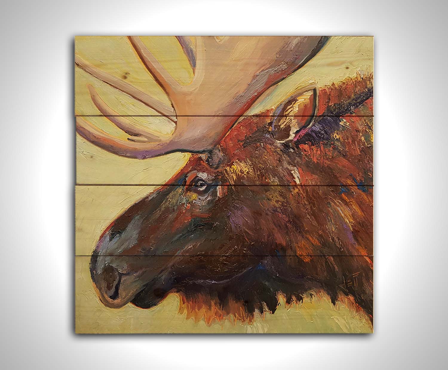 An expressive painting of a moose's face against a pale yellow background. Printed on a wood pallet.