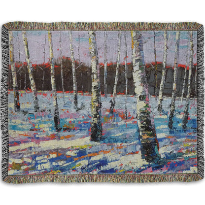 Woven throw blanket printed with an abstract painting of birch trees in a snowy landscape.
