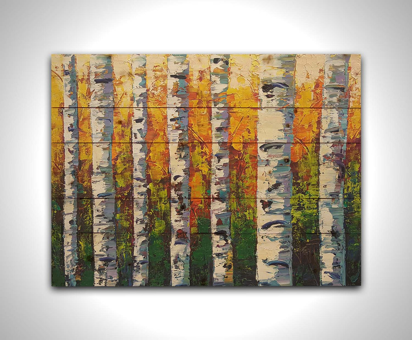 A painting of a birch forest, the stark white tree trunks contrasted by the vibrant green grass and orange leaves of the rest of the forest behind them. Printed on a wood pallet.