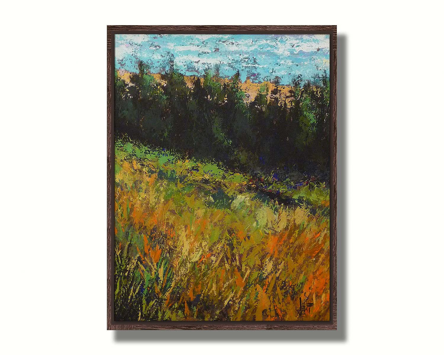 A painting of a grassy green and orange hill, lined in the distance by evergreen trees. Printed on canvas in a float frame.