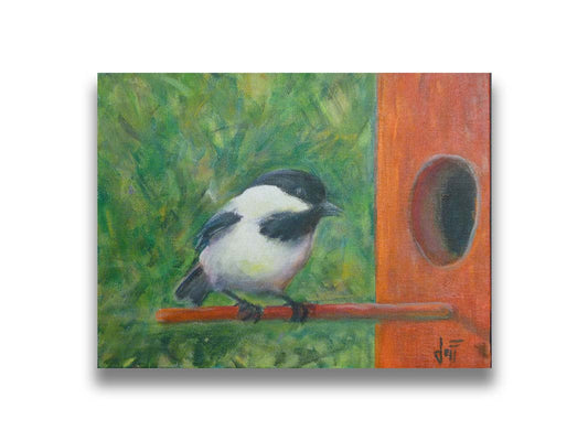 A painting of a black and white chickadee perched on an orange birdhouse, about to enter. The visible brushstrokes of the green background give the impression of foliage. Printed on canvas.