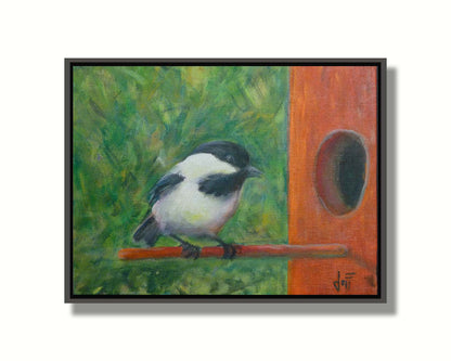 A painting of a black and white chickadee perched on an orange birdhouse, about to enter. The visible brushstrokes of the green background give the impression of foliage. Printed on canvas in a float frame.