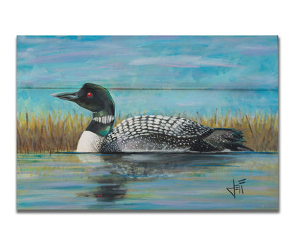 A painting of a loon swimming on the water, reflected on the surface. Printed on a box board.