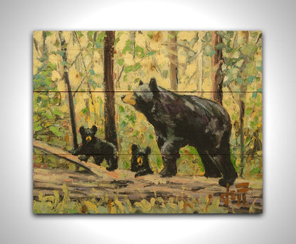 A painting of a family of three bears, walking through the forest over a log. Printed on a wood pallet.