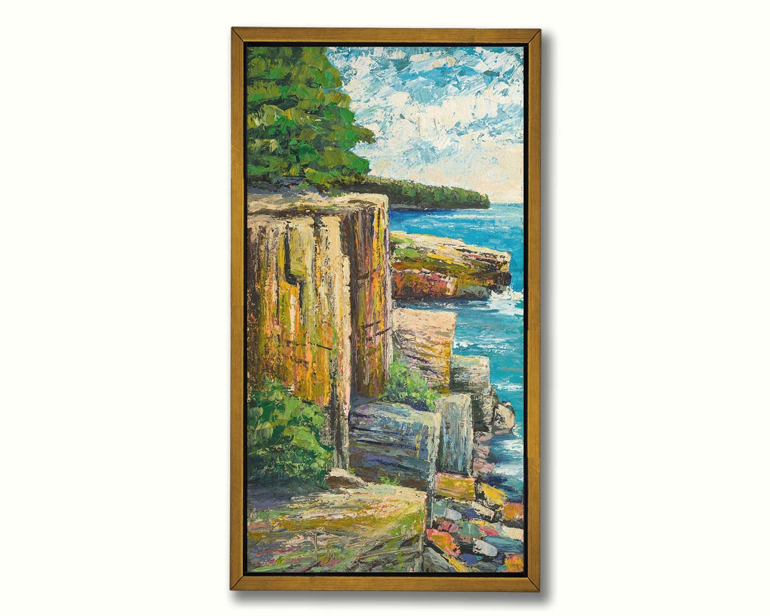 A painting overlooking a waterside clifface. Green forests grow across the tops of the cliffs, and the bright blue waters below splash against a colorful collection of rocks. Printed on canvas in a float frame.