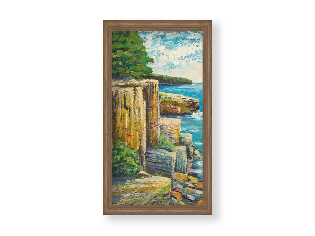 A painting overlooking a waterside clifface. Green forests grow across the tops of the cliffs, and the bright blue waters below splash against a colorful collection of rocks. Printed on canvas and framed.